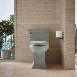 One-piece compact elongated toilet with skirted trapway, 1.28 gpf